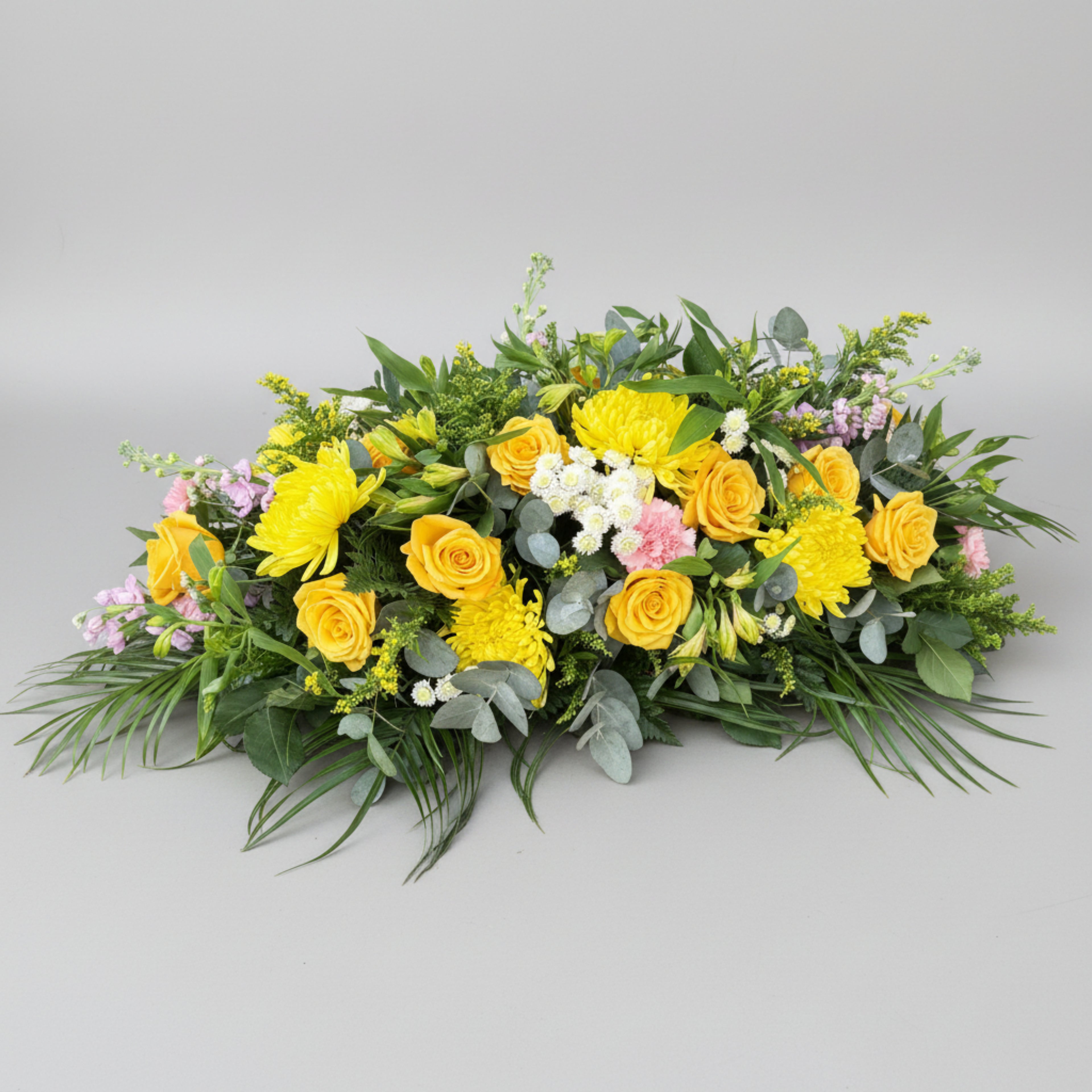 a 4 ft double ended funeral spray with fresh flowers in yellow, with roses, chrysanthemums, carnations and stocks with various foliage