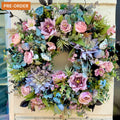 front door artificial wreath by jamesia blooms, pink, blue and grey faux flowers and foliage, hanging on a wall