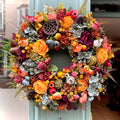 artificial autumn wreath with smoky hydrangeas, yellow roses, woodland accent including lotus flower, pinecones and other autumn toned flowers