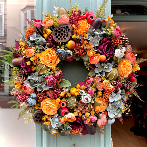 artificial autumn wreath with smoky hydrangeas, yellow roses, woodland accent including lotus flower, pinecones and other autumn toned flowers