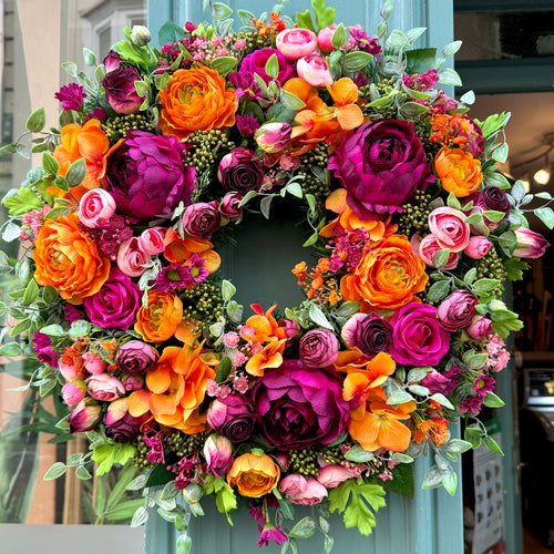 close up detail of high quality faux orange and pink ranunculus with cranberry peonies on jamesia blooms cranorange wreath