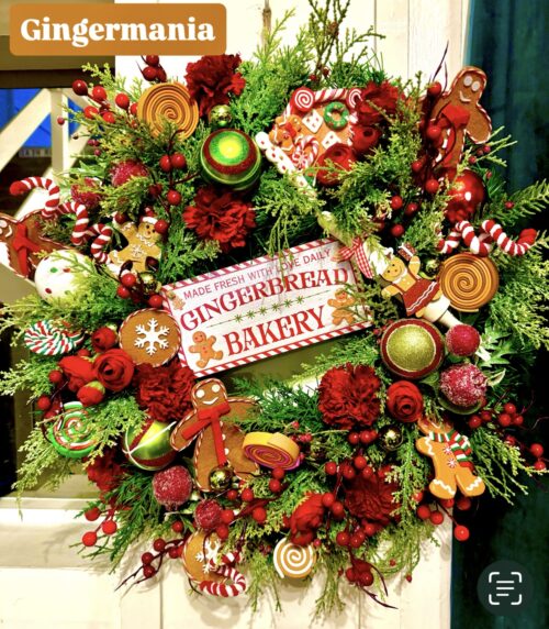 Gingermania Christmas wreath made on a spruce base with various gingerbread and candy cane ornaments with artificial flowers and seasonal foliage