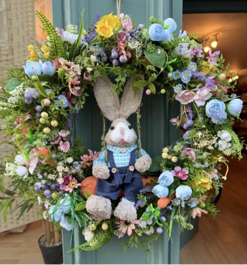 artificial easter wreath of a straw bunny on a swing